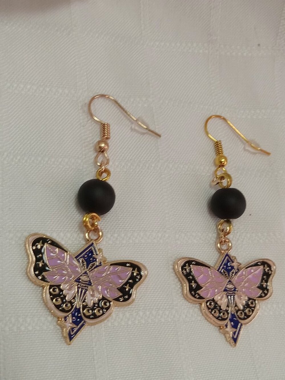 Handmade gold-colored earrings with multicolored enameled butterflies and beads